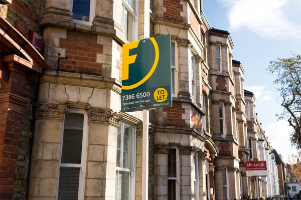 A Victorian terraced house with a To Let sign outside